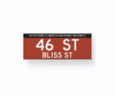 Two replica street name signs for Sunnyside Gardens Historic District, one indicating 'SKILLMAN AV LEWIS MUMFORD WAY' and the other indicating '46 ST BLISS ST'. Both signs have a red background with white text.