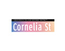 A replica street sign reading 'Cornelia St' in a multicolor design with a cloud motif, indicative of the Greenwich Village Historic District.