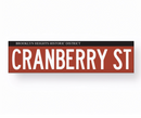 A collection of replica street name signs for Brooklyn Heights Historic District, featuring various street names printed in white on a colored background, with a reflective material-like texture.