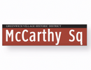 Street sign for McCarthy Sq in Greenwich Village Historic District on a white background