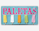 A full-color banner with the text 'PALETAS' displayed in large letters, accompanied by images of various flavored paletas (ice pops) on sticks.