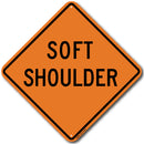 An orange road sign with the words 'SOFT SHOULDER' and written on it, indicating a soft shoulder condition on the road.